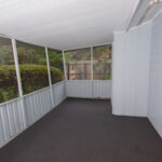 Screened porch with carpeted floor.