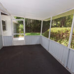 Carpeted screened-in porch with door.