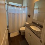 Small bathroom with white vanity and shower.