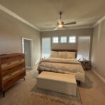 Master bedroom with dresser and bed.