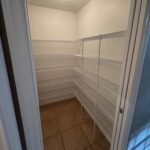 Empty white pantry with wire shelving.