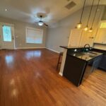 Hardwood floors, kitchen island, living room.