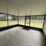 Screened porch with concrete floor.