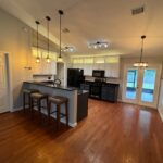 Modern kitchen with hardwood floors and island.