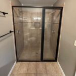 Shower enclosure with glass doors.