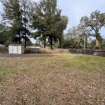 Backyard with shed and wooden fence.