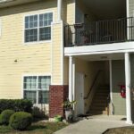 Apartment building entrance with balcony.