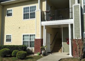 Apartment building entrance with balcony.